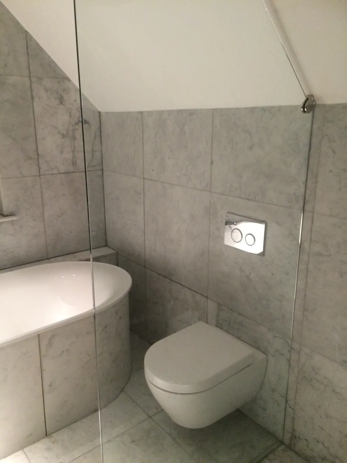Vanity basin with a gold tap against dark wall tiles