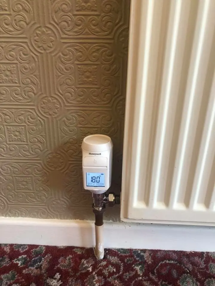 White wireless smart radiator valve on a column radiator
